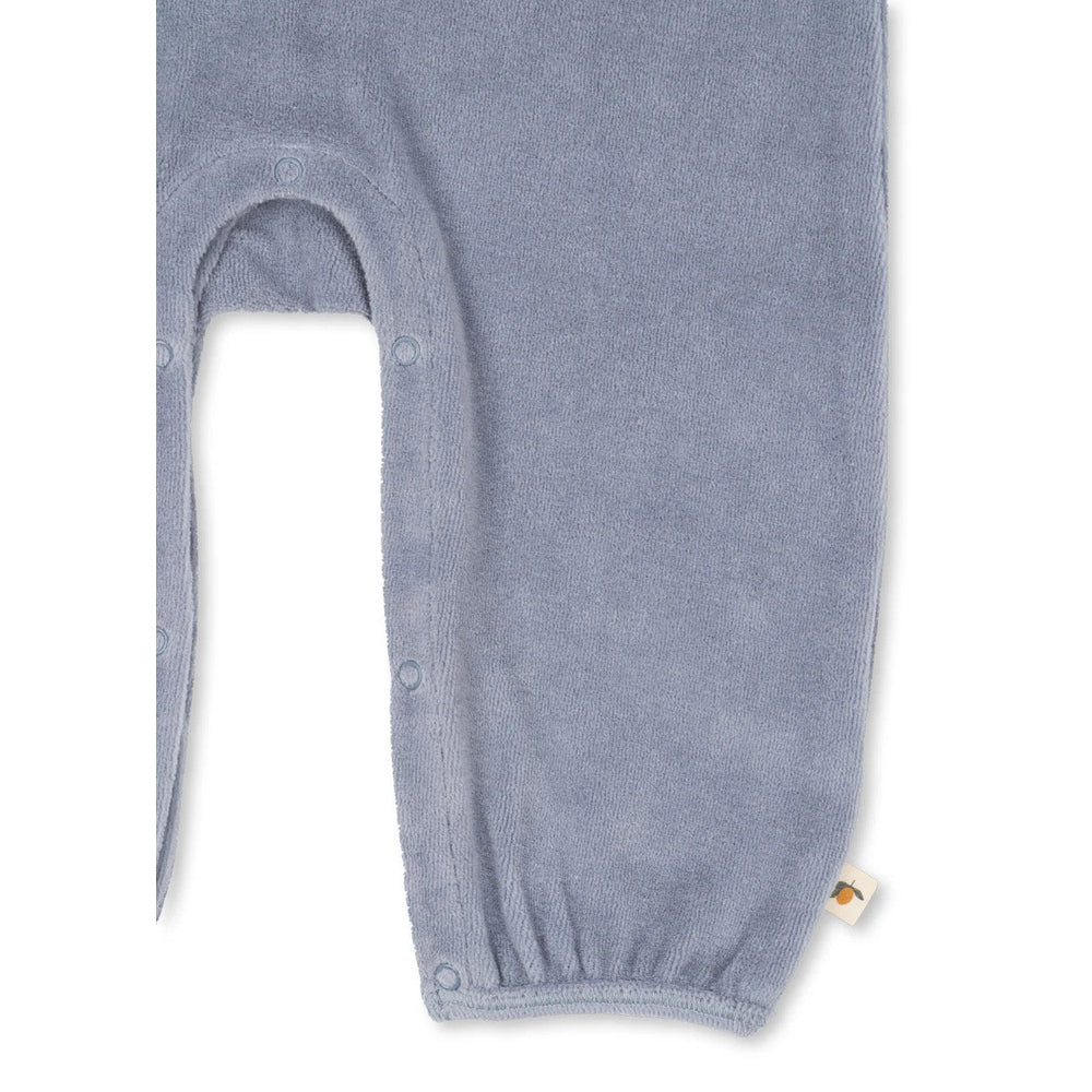 Konges Slojd Miffa Onesie Gots Trade Winds blue terry, leg-snap closures demonstrated for easy changes.