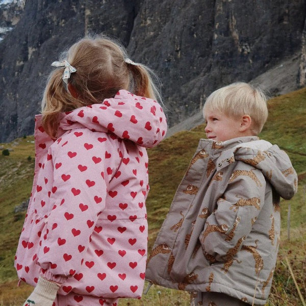 Konges Slojd Mismou Jacket Tiger Oak for toddlers; two kids outdoors in mountains, one in tiger-print beige jacket.