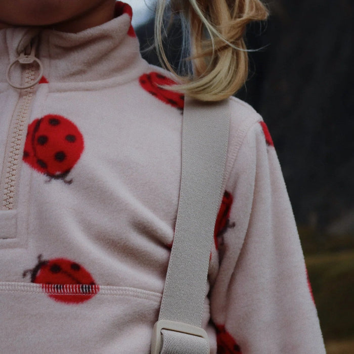 Konges Slojd Tavi fleece sweatshirt for kids in pale pink with red ladybug pattern.