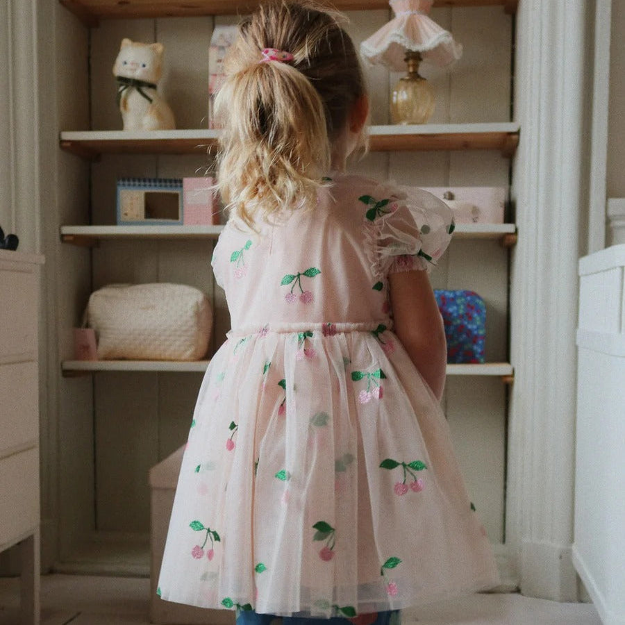 Konges Slojd Tullie Dress Pink Glitter being worn by a girl, pink sheer skirt with cherry print.