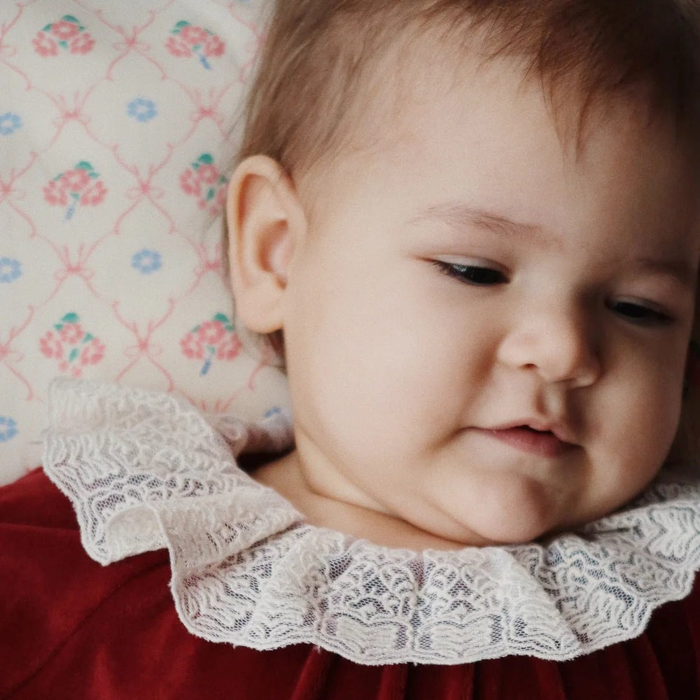 Konges Slojd Venola Romper Red Dahlia, baby wearing a red velvet romper with white lace collar.