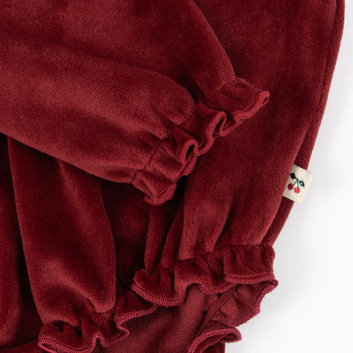 Konges Slojd Venola Romper Red Dahlia, plush red velvet baby onesie with elastic ruffle cuffs on sleeves.