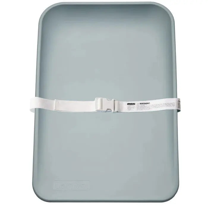 Leander Matty Changer light grey changing mat with white buckle strap fastened across for secure diaper changes.