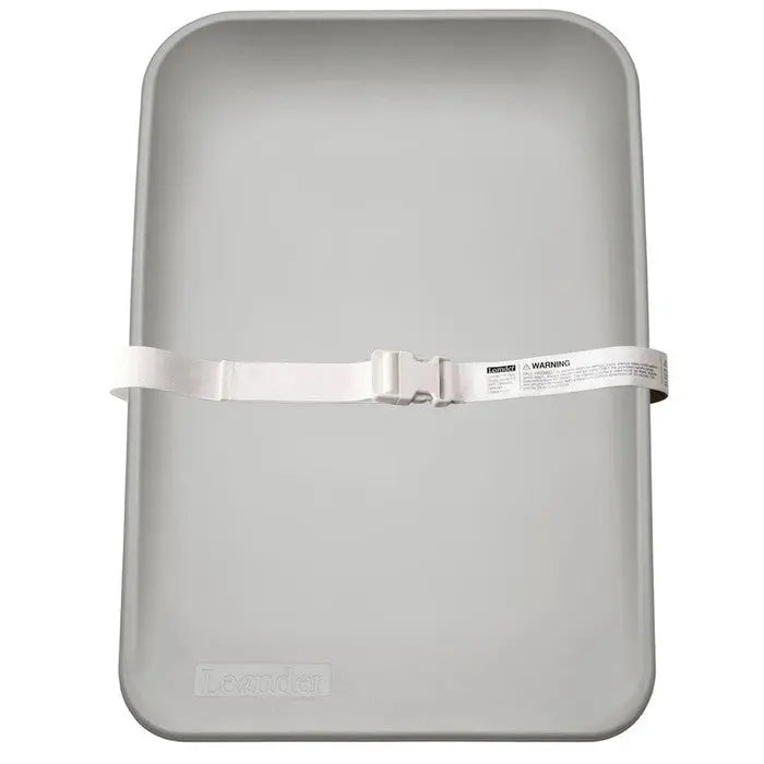 Leander Matty Changer gray changing mat with white safety strap buckled across.