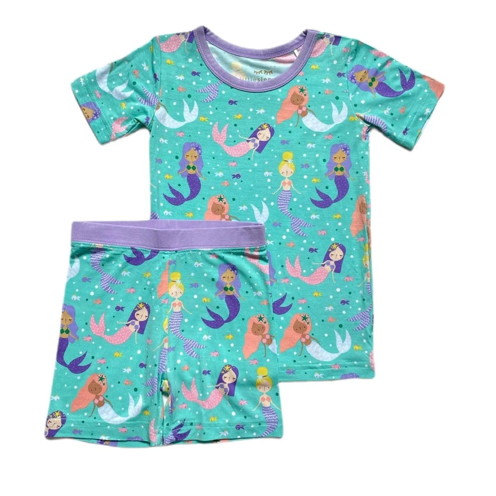 Littlesleepies Mermaid Magic Two Piece Pajama Set, turquoise mermaid print with purple trim, top and shorts laid flat.