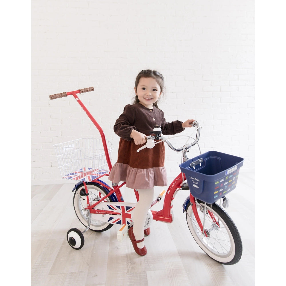 London Taxi 14-Inch Kid's Bike with Pushbar; red frame with Union Jack decals and blue front basket, girl holding handlebars.