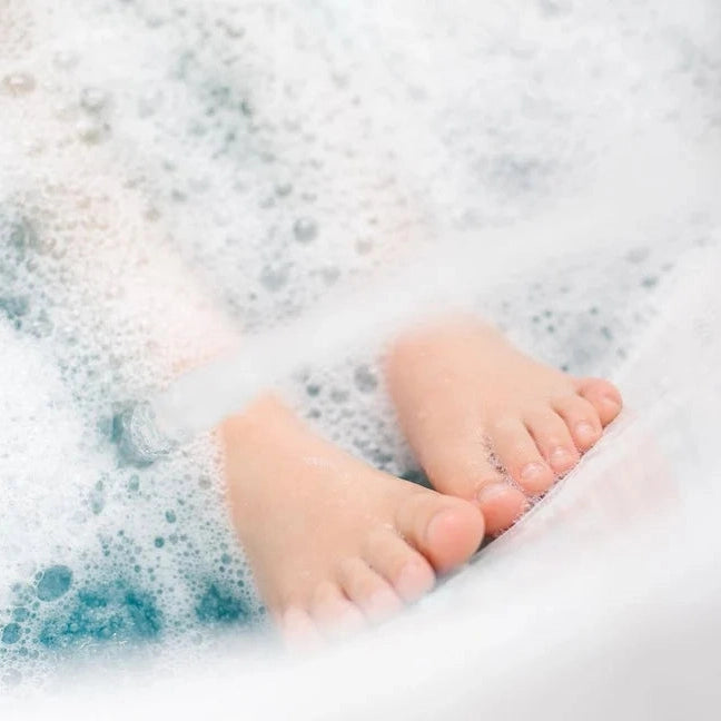 Loot Toy Co Foaming Bath Powder Plum; soothing bath powder in bubbly water with baby feet