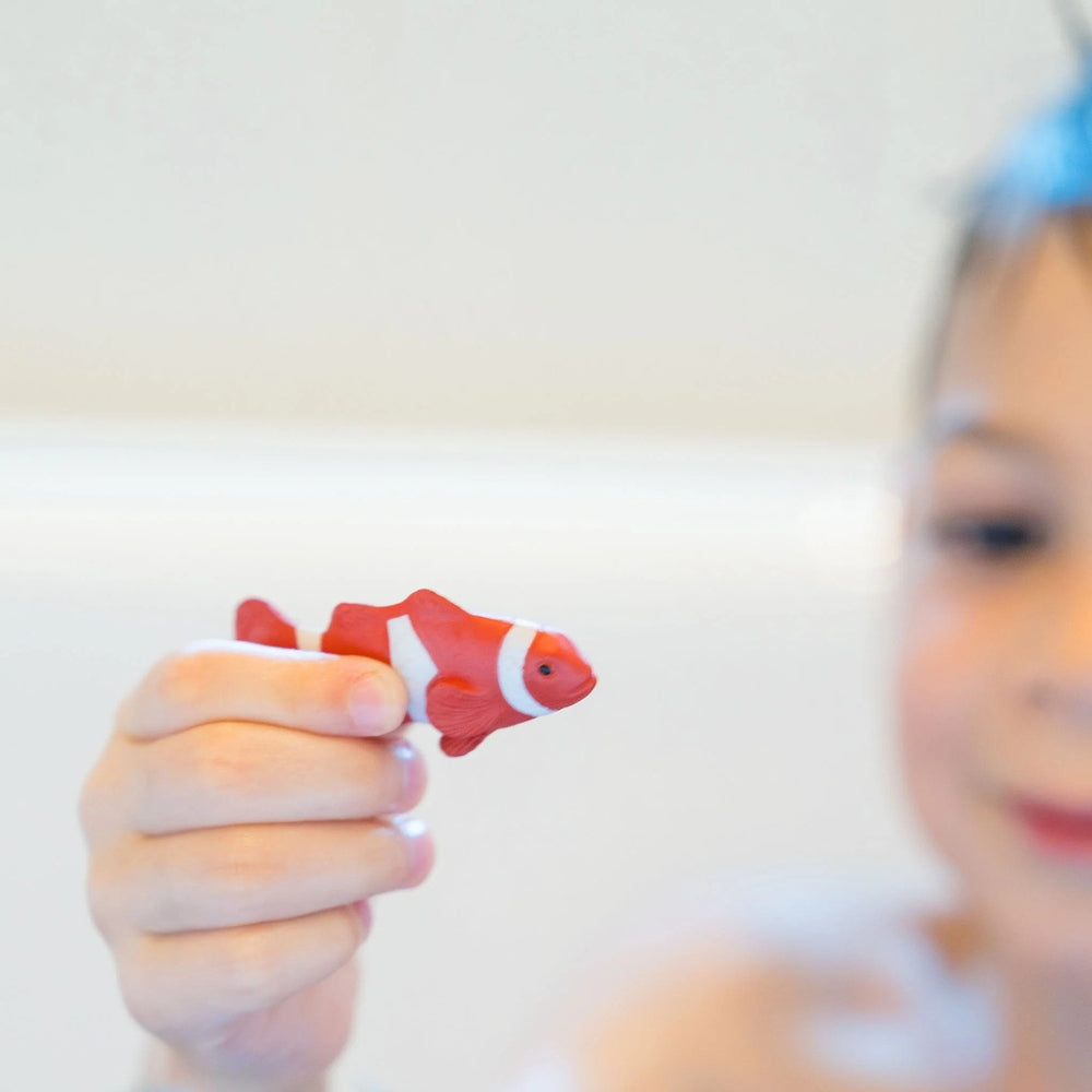 Loot Toy Co Funky Fish Food Mellow Yellow bath toy, orange-red with white stripe, held by child