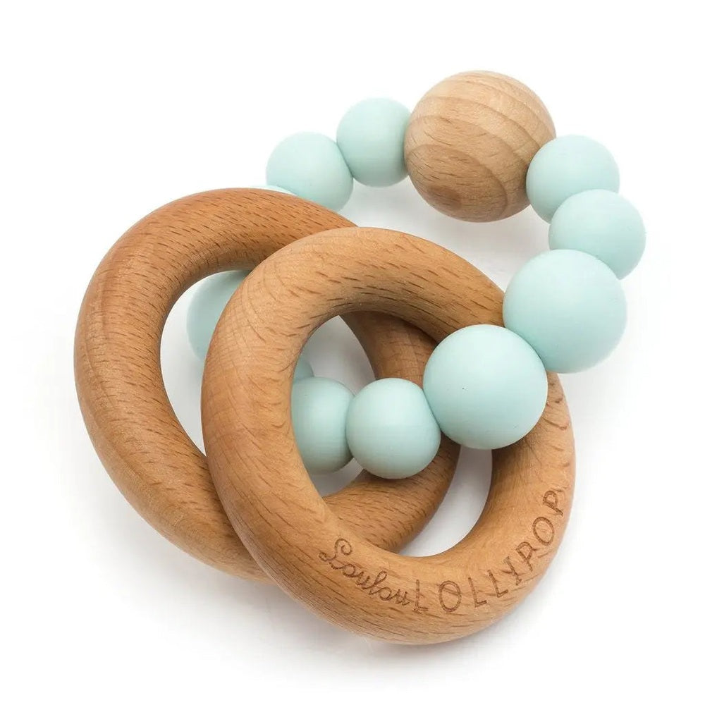 Loulou Lollipop Bubble Silicone and Wood Teether with natural wood rings and mint beads held by a baby.