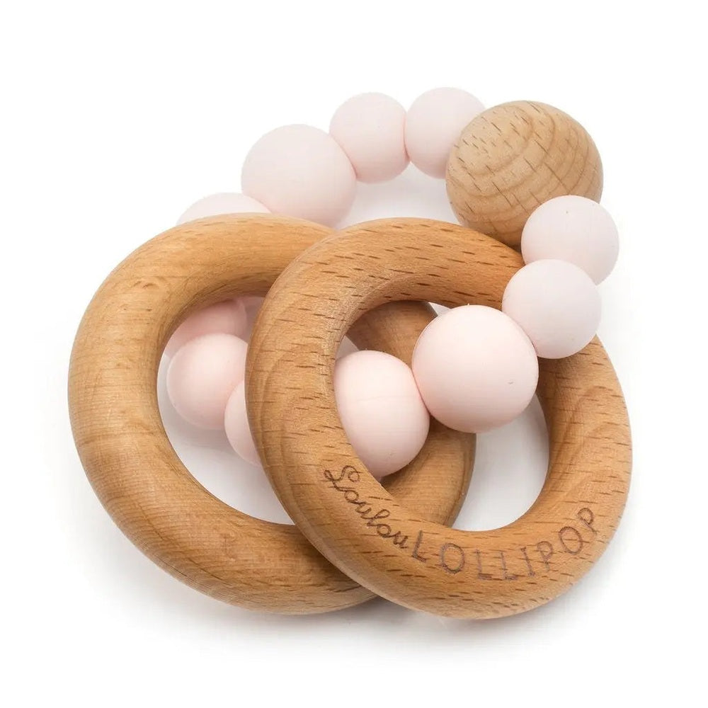 Loulou Lollipop Bubble silicone and wood teether, two natural rings linked with pale pink beads.