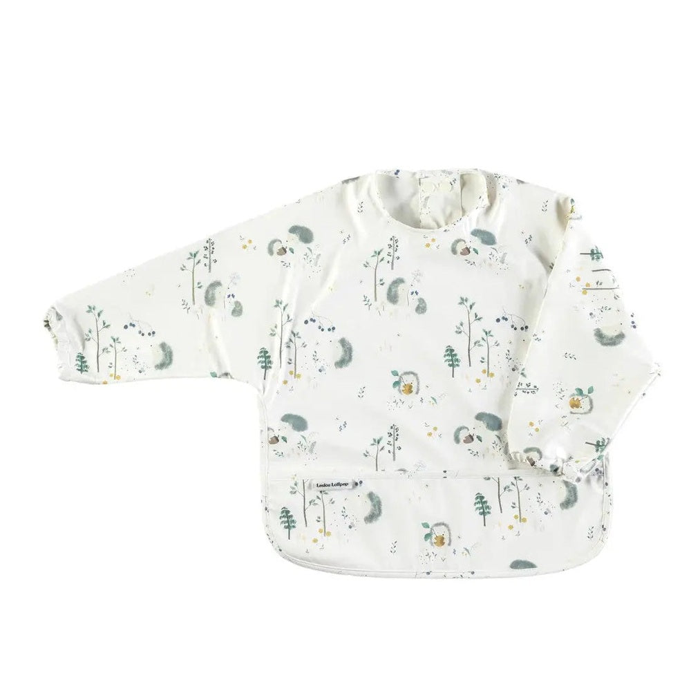 Loulou Lollipop Long Sleeve Waterproof Bib, white with pastel woodland print, sleeves guard outfits during meals.