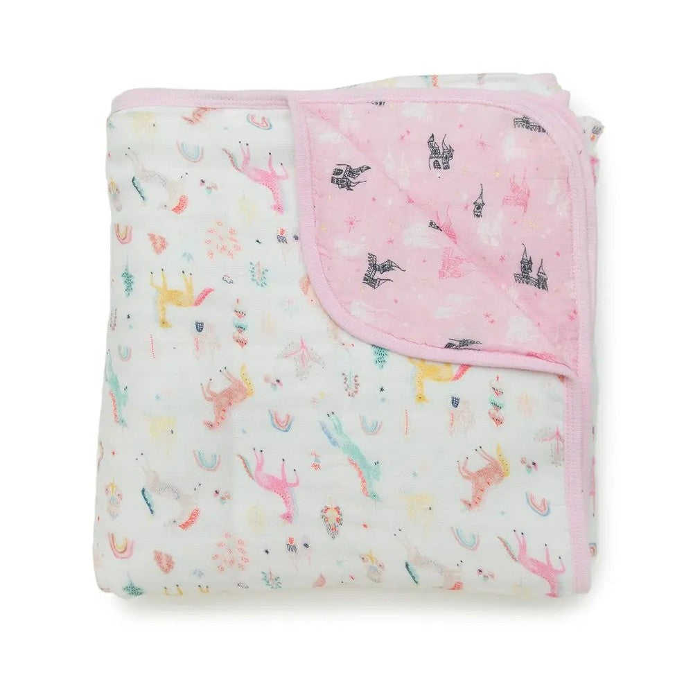 Loulou Lollipop Muslin Quilt Blanket, pastel white with pink corner, folded to reveal whimsical castle prints on pink fabric.