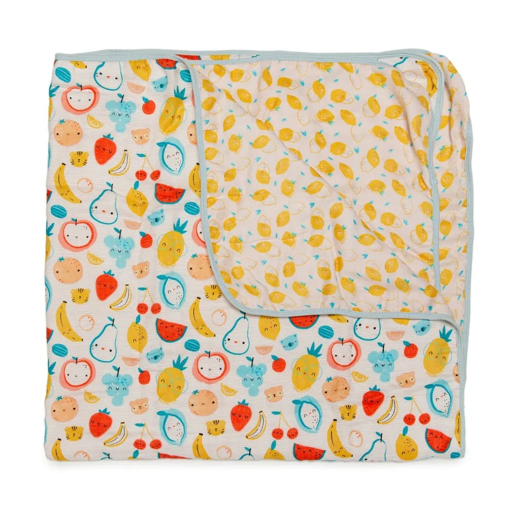 Loulou Lollipop Muslin Quilt Blanket, two-sided fruit prints with blue trim, folded to show both patterns.