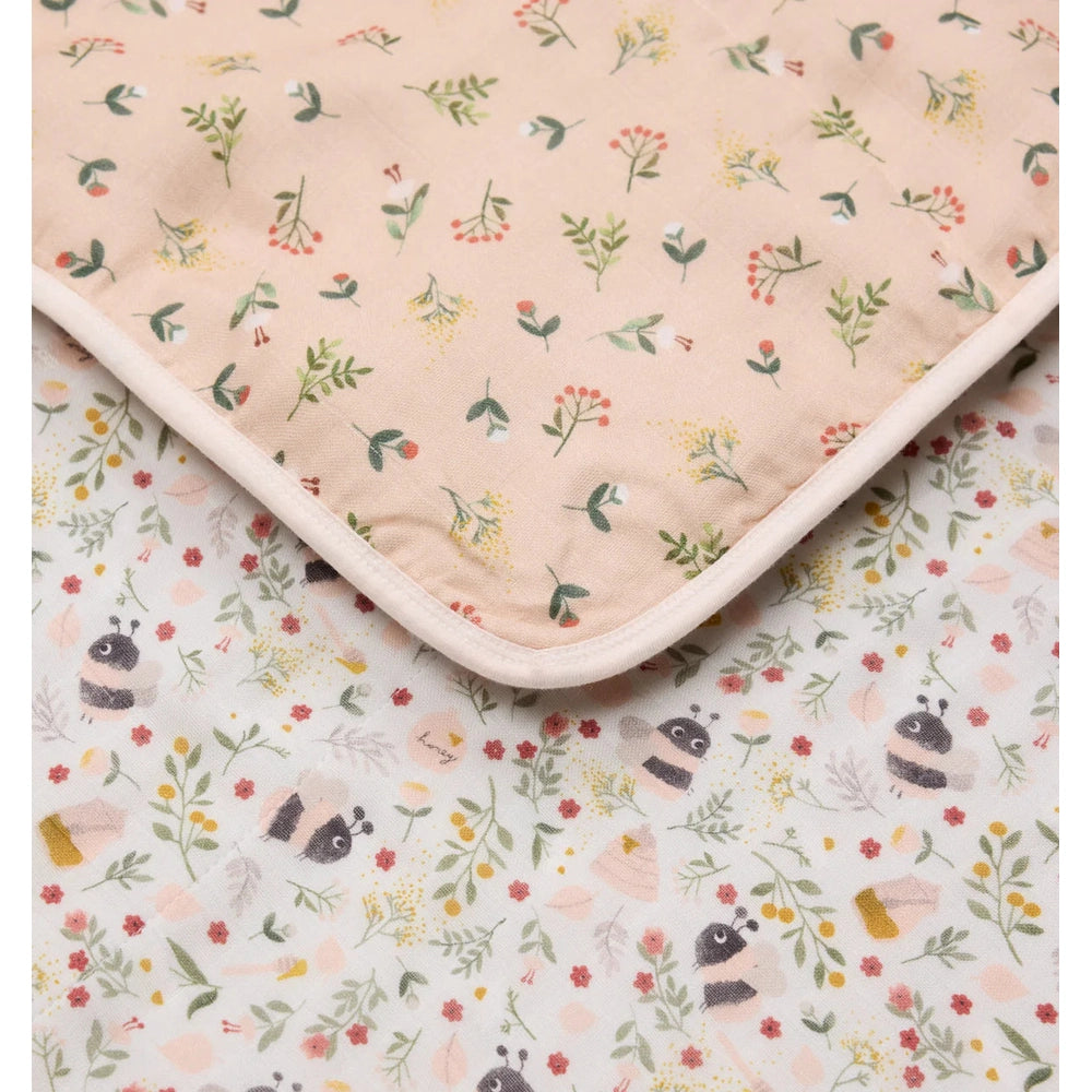 Loulou Lollipop Muslin Quilt Blanket in pink floral bees print, folded corner shows soft binding.