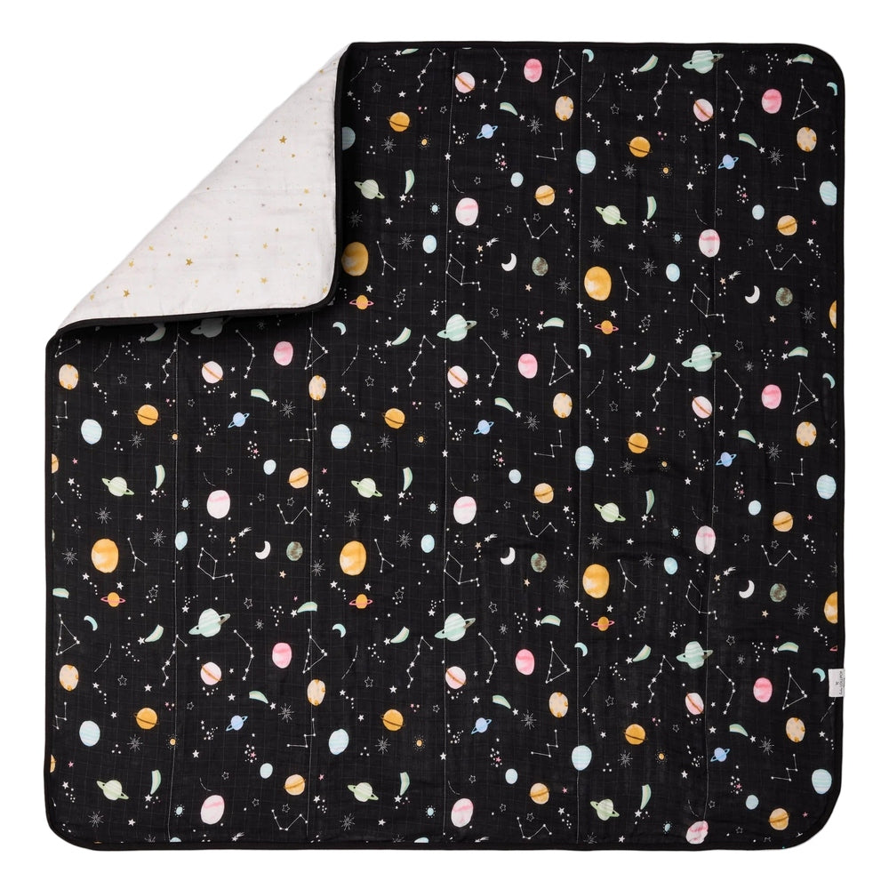 LOULOU LOLLIPOP Muslin Quilt Blanket; black space-print top with planets, pulled back to reveal the soft white muslin reverse.