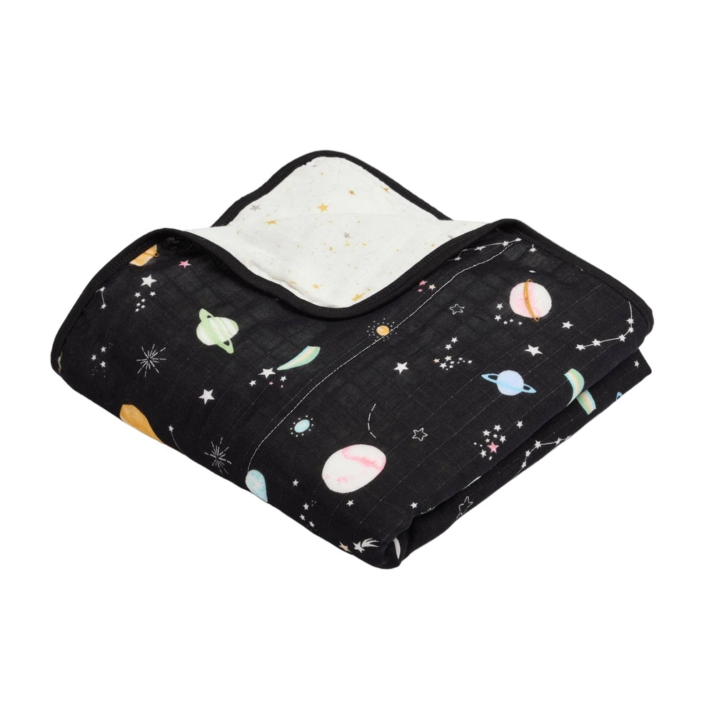 Loulou Lollipop Muslin Quilt Blanket in black space print, folded to show the white interior and planet/star design.