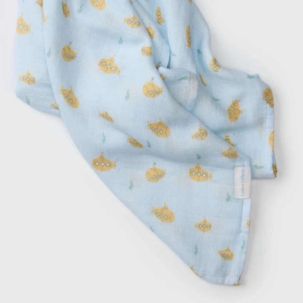 LOULOU LOLLIPOP Muslin Swaddle in light blue with yellow submarine print, gently draped to show soft texture.