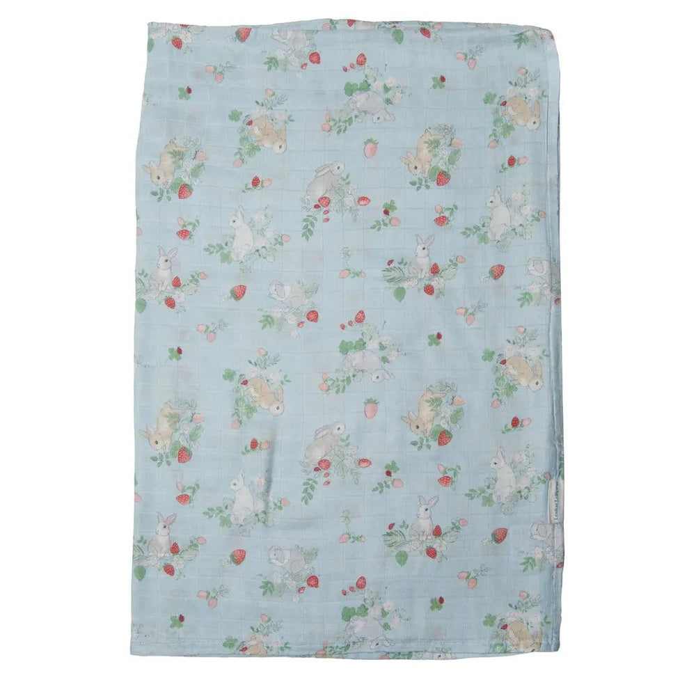 Loulou Lollipop Muslin Swaddle blanket, light-blue with bunny and strawberry print, laid flat for cozy swaddling.