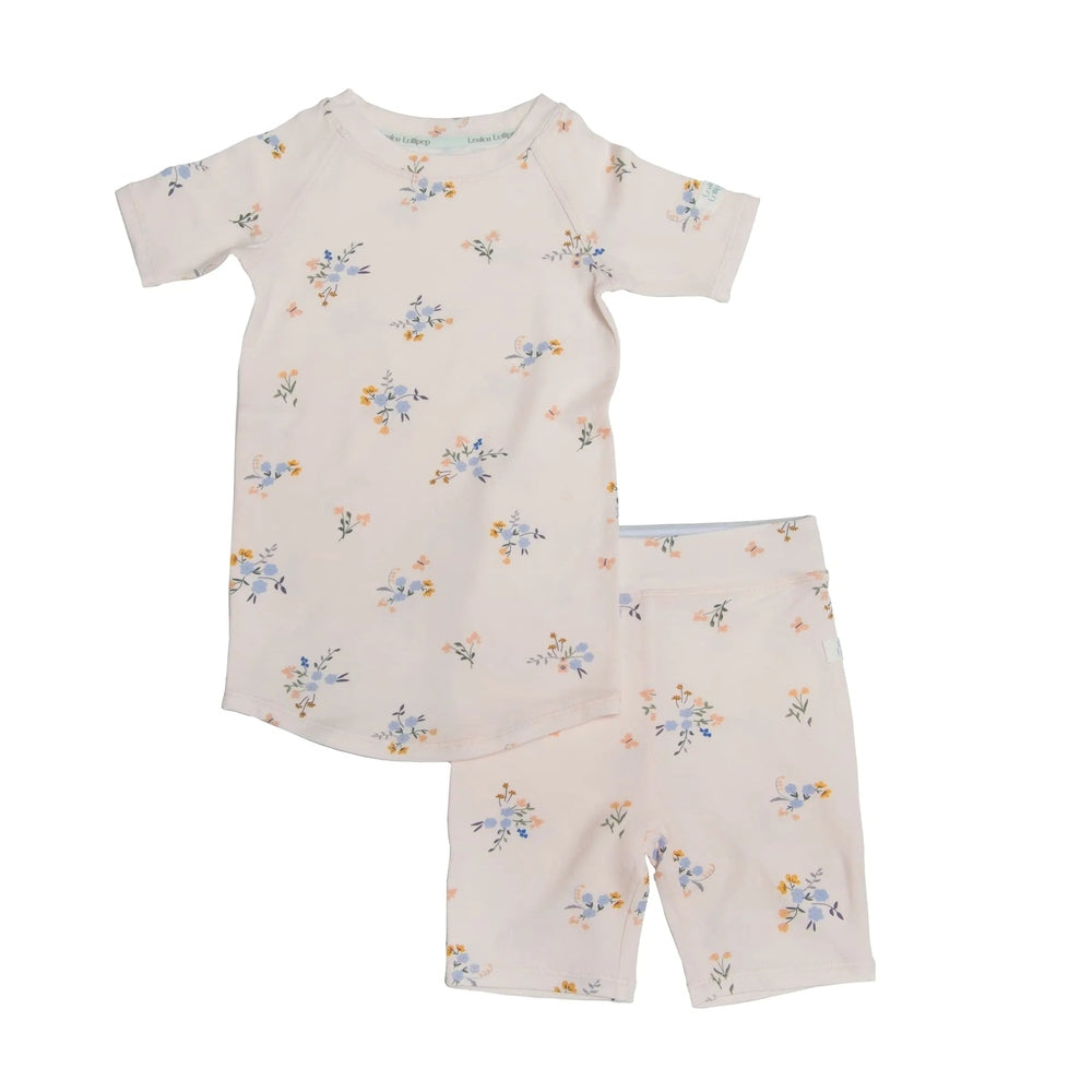 Loulou Lollipop Short Pajama Set Ditsy Floral two-piece laid flat showcasing pale pink fabric and pastel flower print.