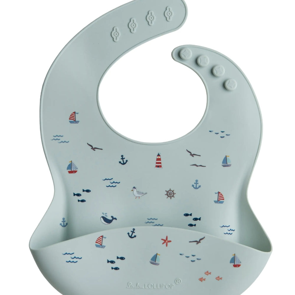 Loulou Lollipop Silicone Bib in light blue nautical print; adjustable neck snaps for a snug fit.