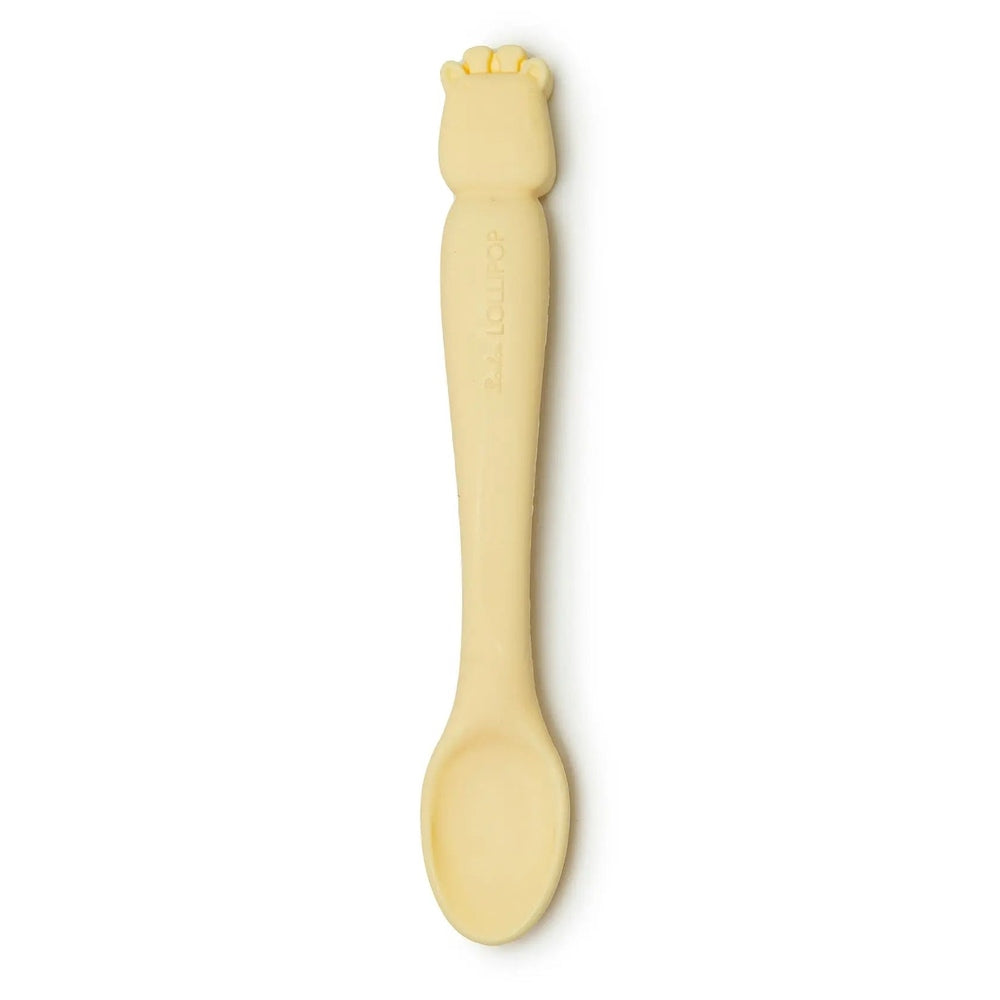 Loulou Lollipop Silicone Feeding Spoon in pale yellow with paw-topped handle, showing soft silicone for babies.