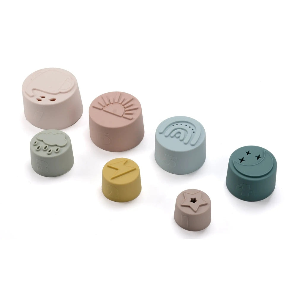 Loulou Lollipop Stacking Cups: eight pastel silicone cups stacked together, showing sun, rain, and star designs.