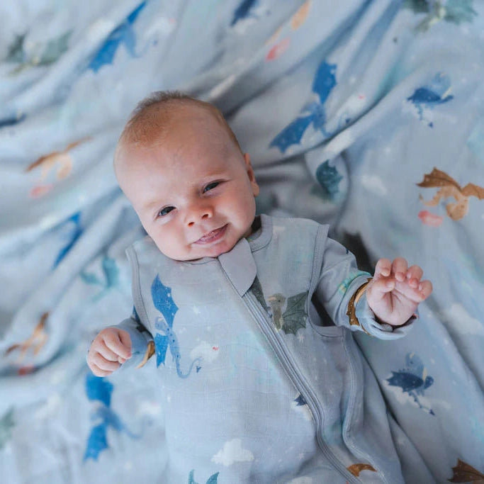 Loulou Lollipop TENCEL Sleep Bag 1.0 TOG Magical Dragons, light blue with dragon print, baby smiling in the cozy sleep sack.