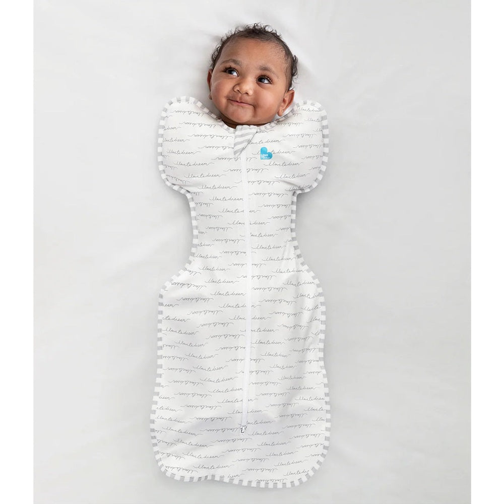 Love To Dream Swaddle Up Original Cotton 1.0 Tog White Dreamer baby swaddle, infant lying on back with arms up.