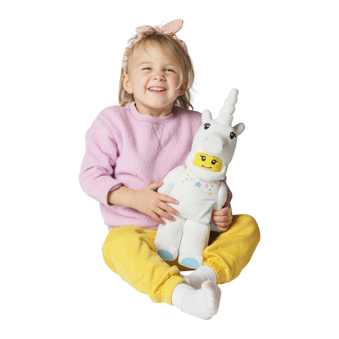 Child holding the Manhattan Toy LEGO Iconic Unicorn Plush Minifigure during play
