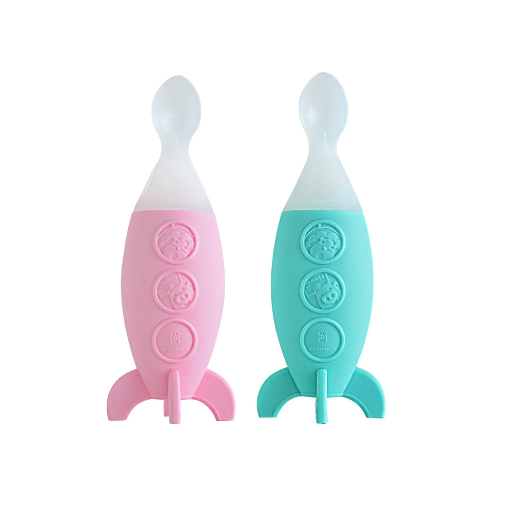 Marcus & Marcus Feeding Spoon Dispenser Rocket in pink and turquoise silicone with clear tops, 2-pack, shown standing side by side