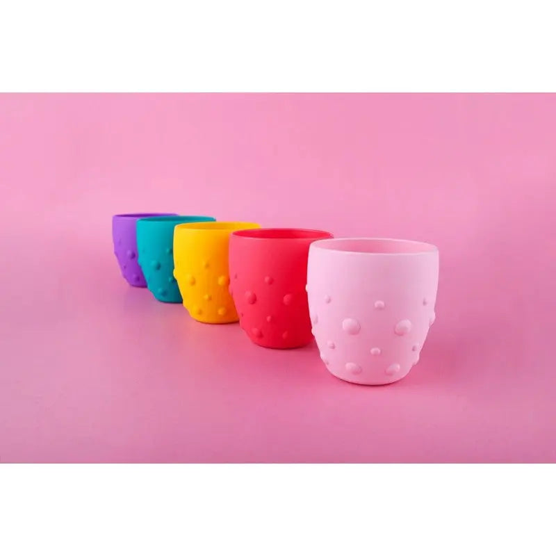 Marcus & Marcus Training Cup, silicone cups set of 5 in bright colors lined up on pink backdrop.