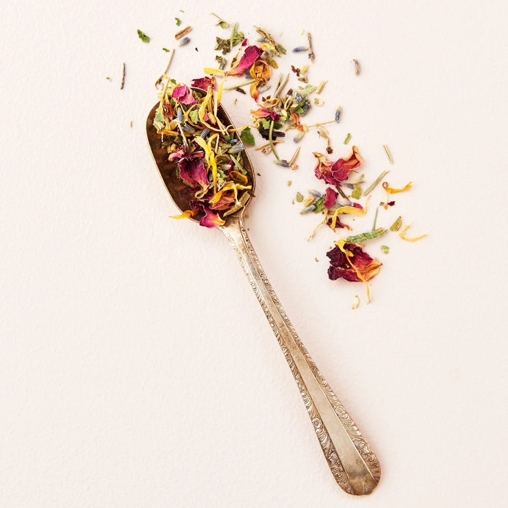 Matter Company Substance Herbal Sitz Bath in ornate silver spoon with colorful dried herb petals.