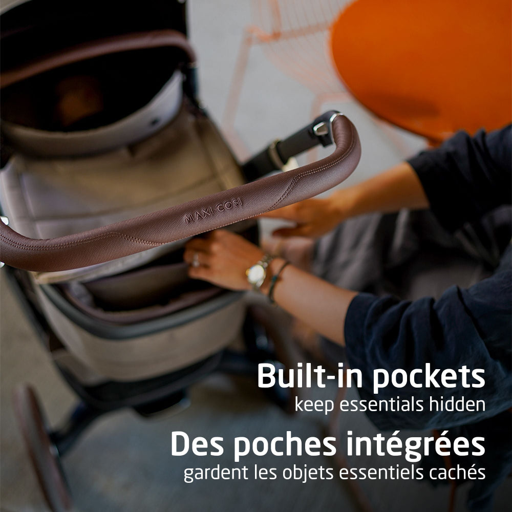 Maxi-Cosi Fame carry cot with brown leather handle and built-in pockets for strollers.