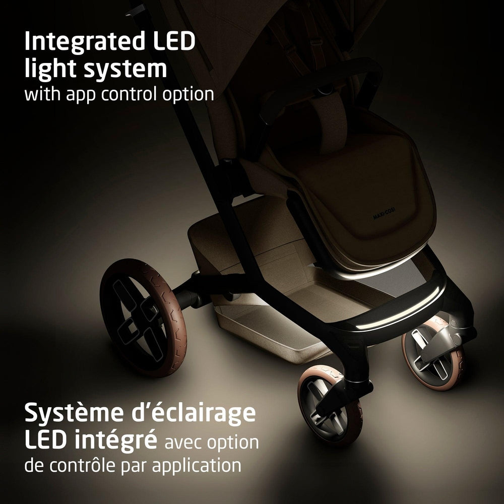 MAXI COSI Fame stroller with integrated LED lighting and brown wheels, gliding with a lit front bar.