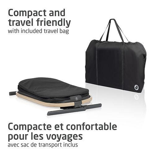 Maxi Cosi Iora bedside bassinet, compact and travel-friendly, folded beside the included travel bag.