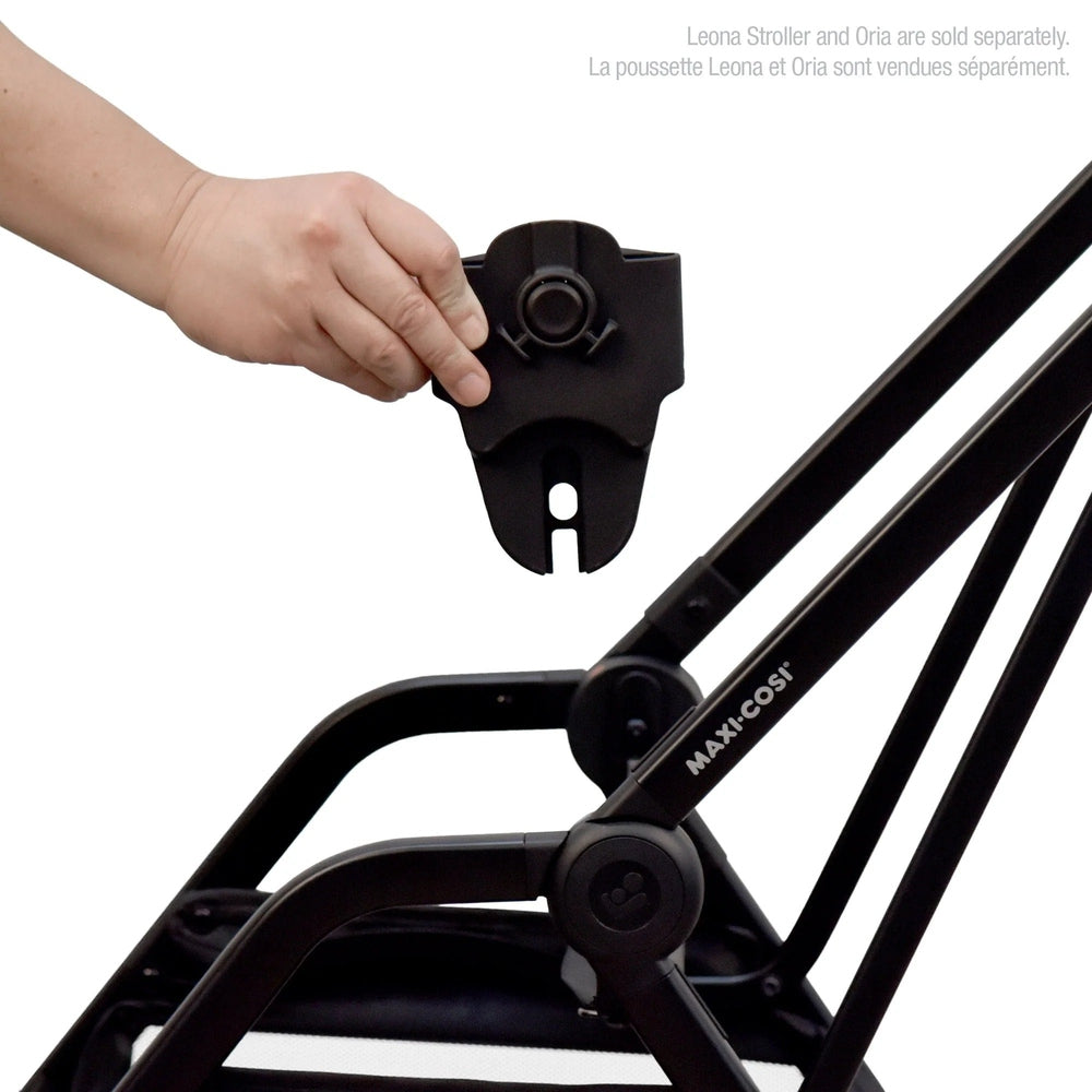 MAXI COSI Leona stroller Oria adapter held by hand on a black stroller frame