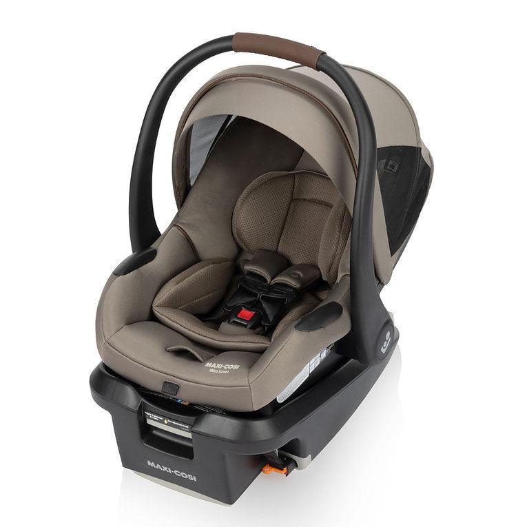 MAXI COSI Mico Luxe+ infant car seat in beige-brown fabric with base and raised carry handle.