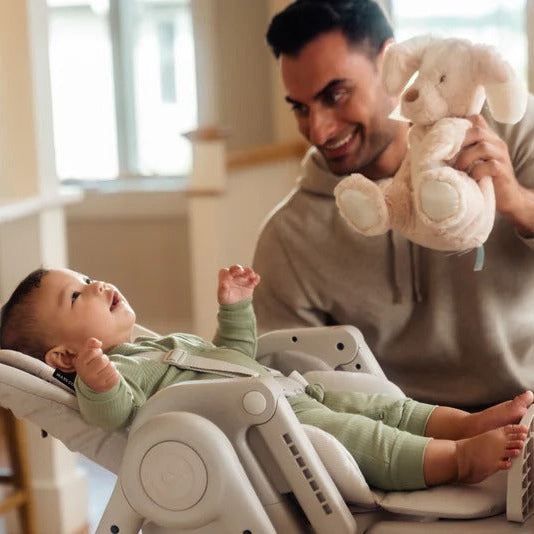 Maxi-Cosi Minla 6-in-1 high chair in gray, shown with a baby and an adult holding a stuffed bunny