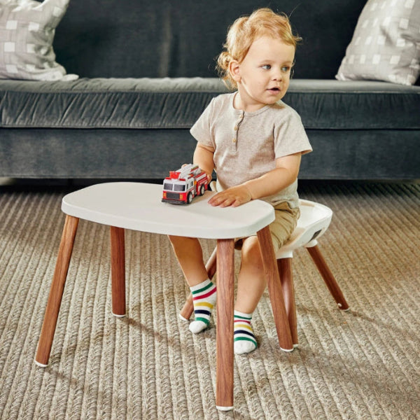 Maxi Cosi Moa 8-in-1 High Chair, white with wooden legs; child seated with toy fire truck