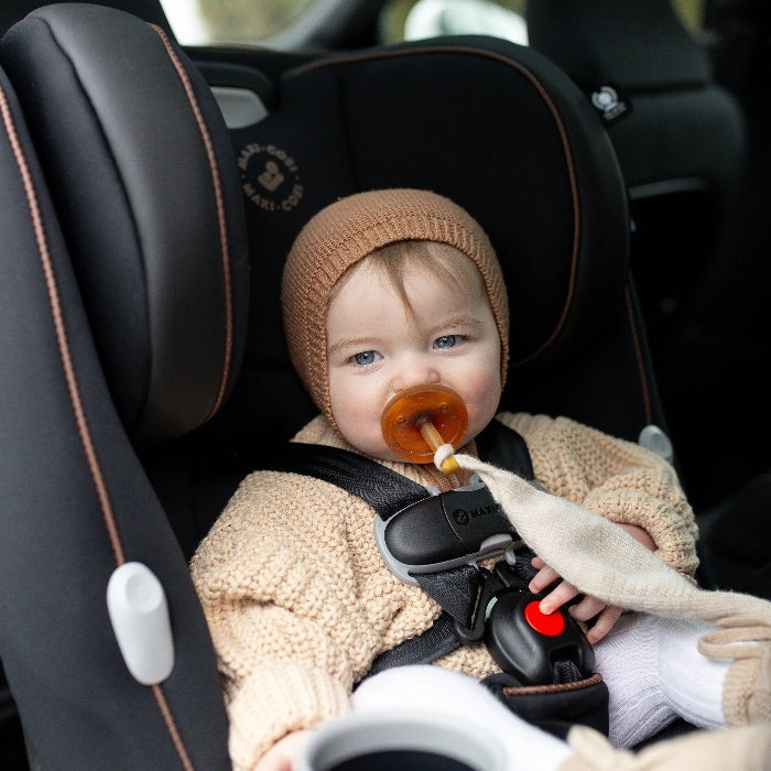 Maxi-Cosi Pria All In One convertible car seat with a baby in beige knitwear and brown hat