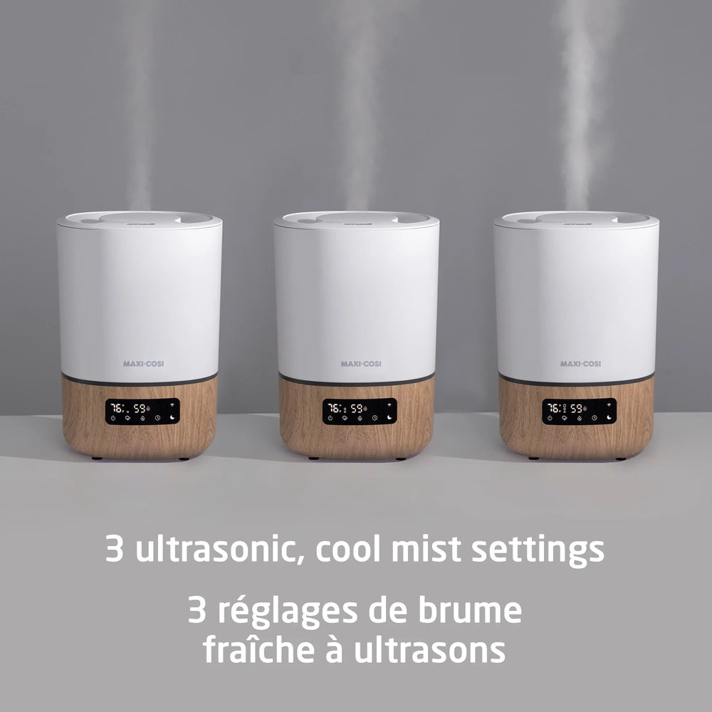 Maxi Cosi Smart Humidifier, white with wood base, three units emitting cool mist in a row.