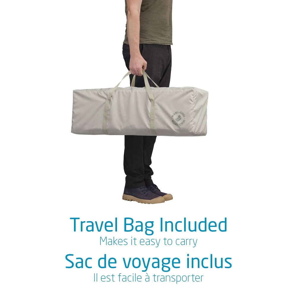 Maxi Cosi Swift Playard in beige travel bag carried by a person, proving portable bassinet portability.