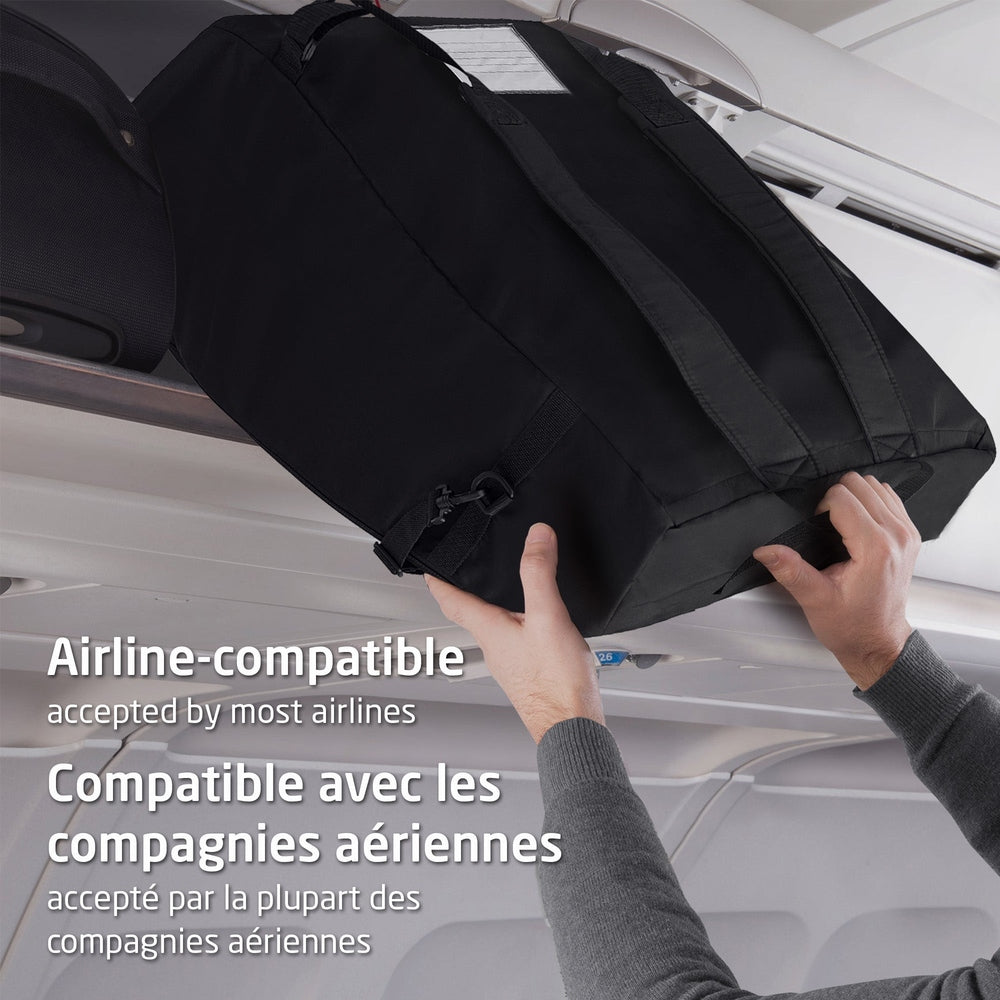 MAXI COSI Ultra Compact Travel Bag in black, airline-compatible, being loaded into an airplane's overhead bin.