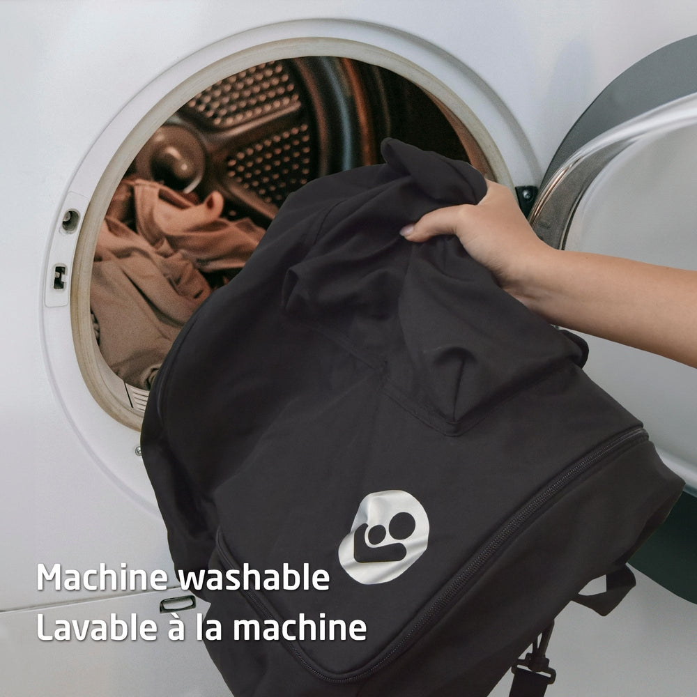 Maxi Cosi Ultra Compact Travel Bag, machine washable, shown being inserted into a washing machine.