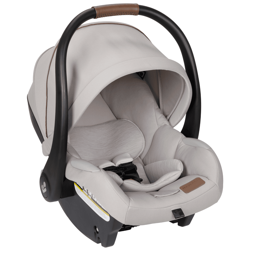 Maxi-Cosi Zelia Luxe 5-In-1 infant car seat in beige with a curved black frame and brown grip handle