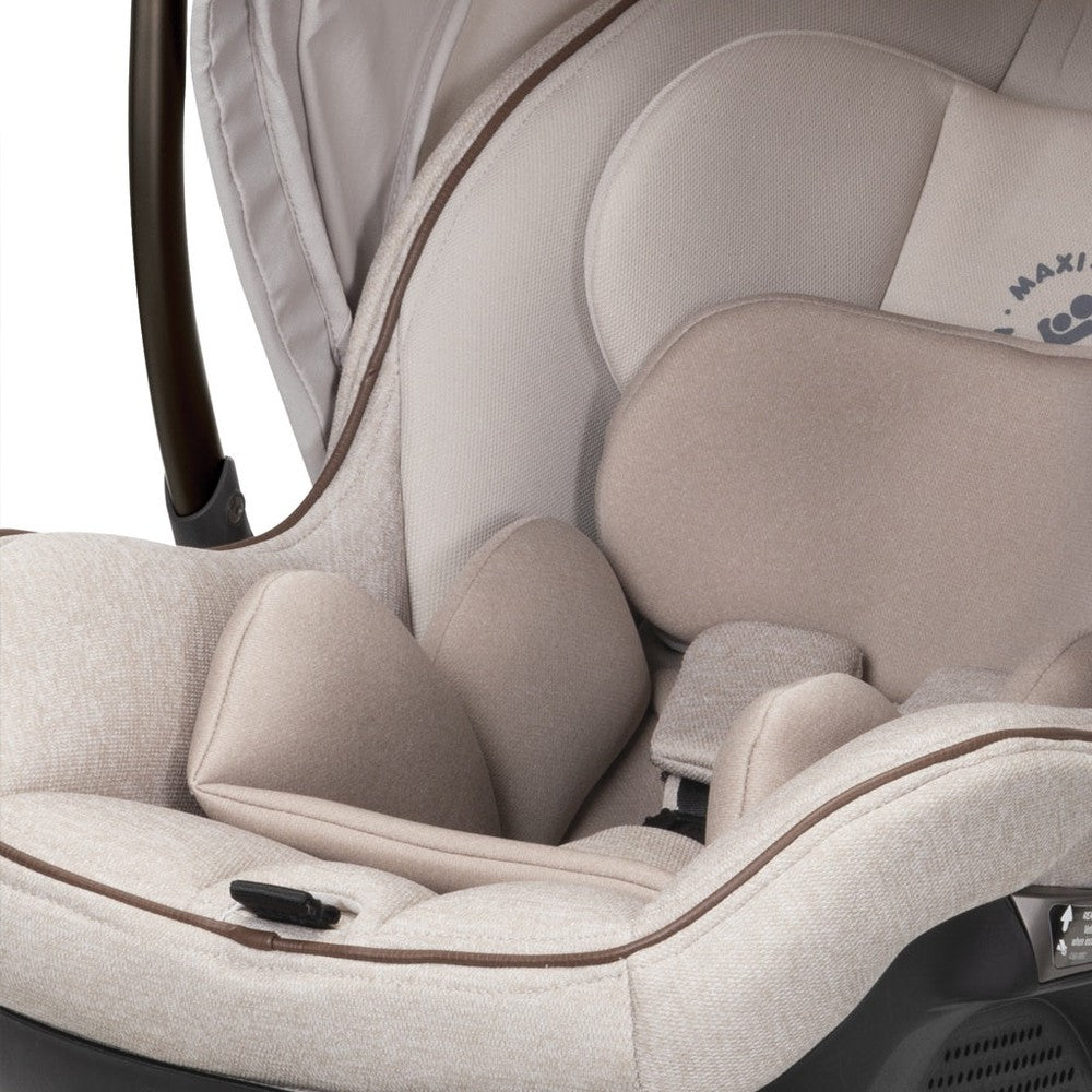 Maxi-Cosi Zelia Luxe 5-in-1 modular travel system in beige fabric, plush padded stroller seat with harness.