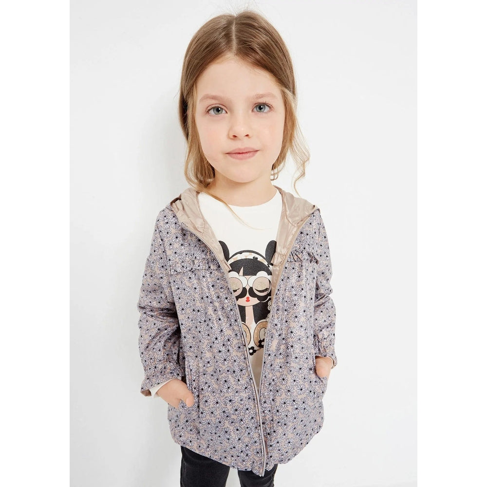 Mayoral reversible windbreaker jacket almond in lavender floral print with beige lining, girl with hands in pockets.