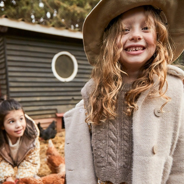 MAYORAL knitting vest in brown knit worn by a smiling toddler outdoors