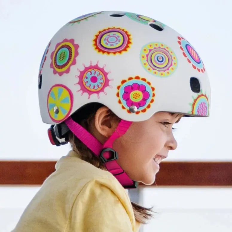 Micro Helmet V2 Doodle Dot white kids riding helmet with bright circular decals and pink chin strap on a smiling child