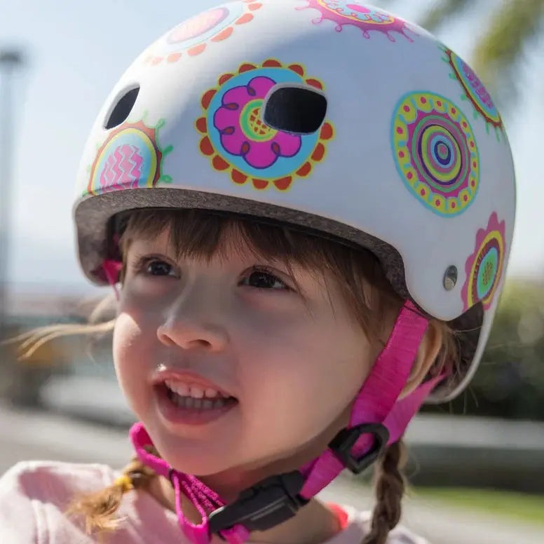 Micro Helmet V2 Doodle Dot for kids, white shell with bright circular doodles; pink chin strap on a smiling child.